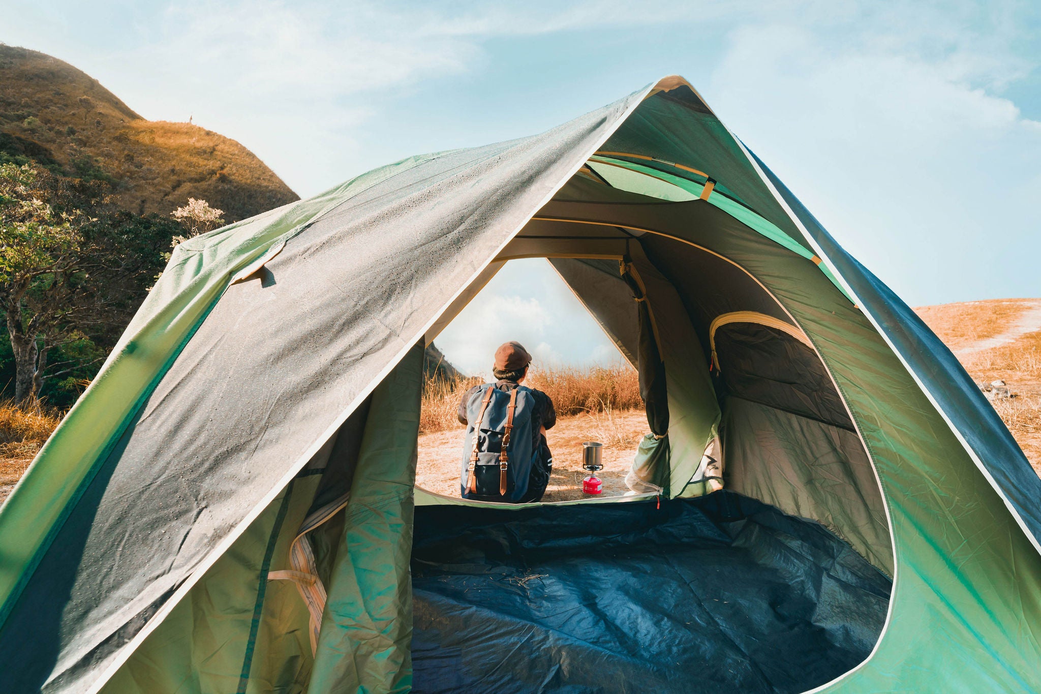 Wanderlust and relax in nature with hiker man camping on top of mountain on spring and summer season