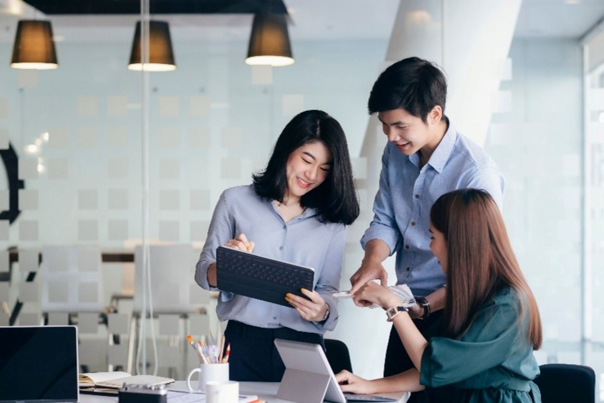 Team collaborating around a tablet in an office.