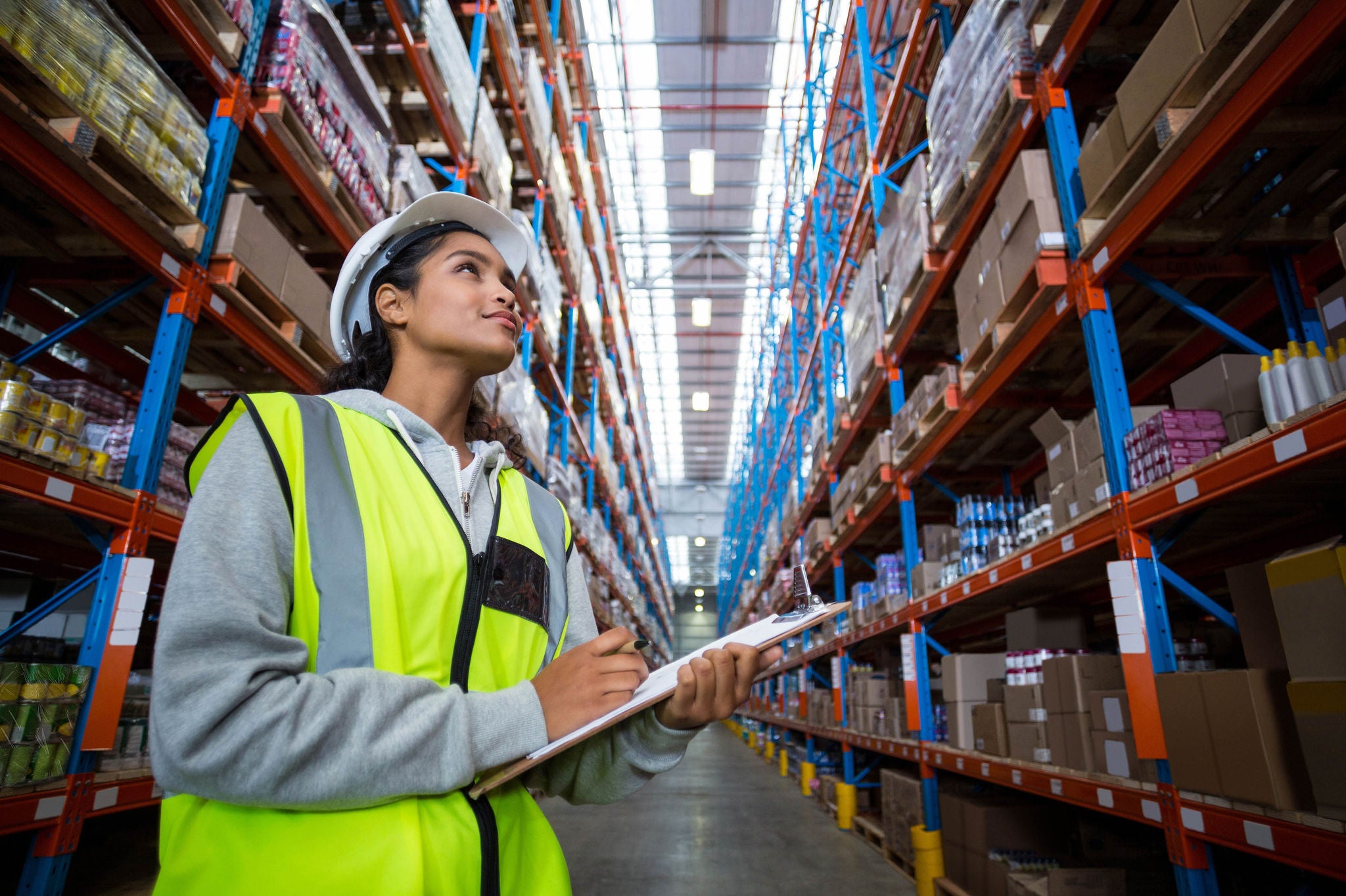 Female warehouse worker looking at packages