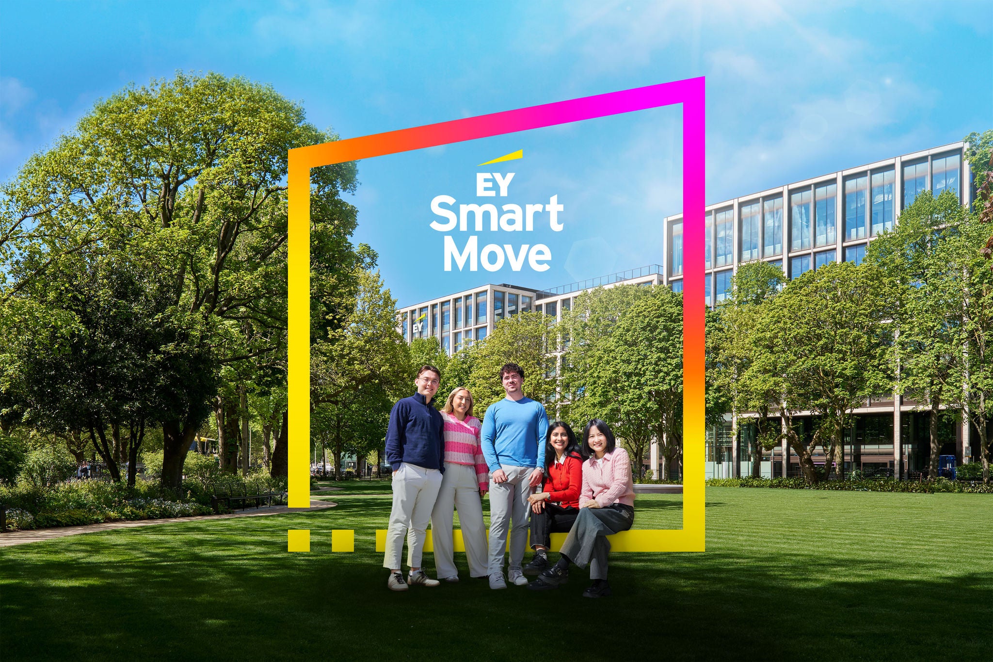 Group of graduates gathered in a landscaped park area with modern office buildings and EY Smart Move branding.