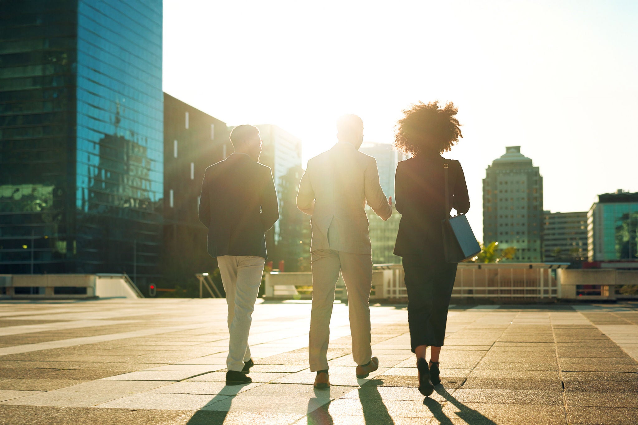 Business team and walking outdoor in city for morning travel to work, conversation and lens flare