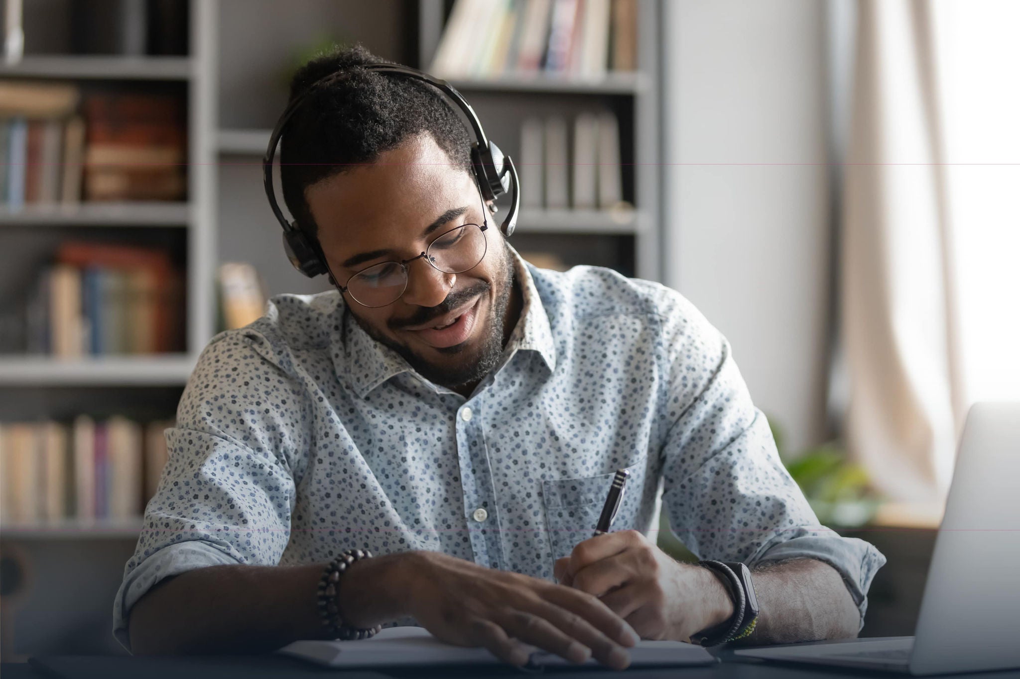 man in a virtual call taking notes