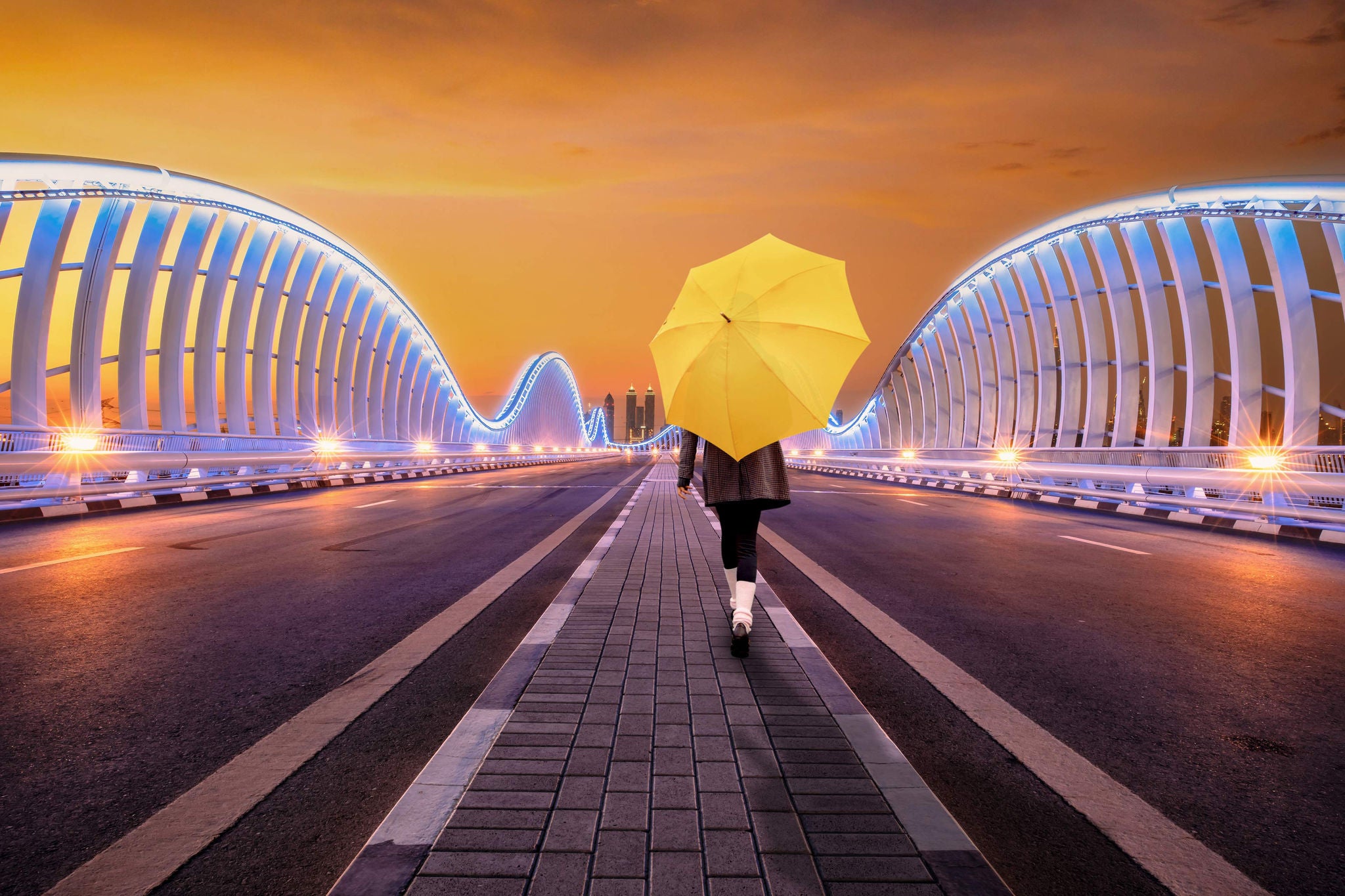 Women with umbrella walking across bridge background