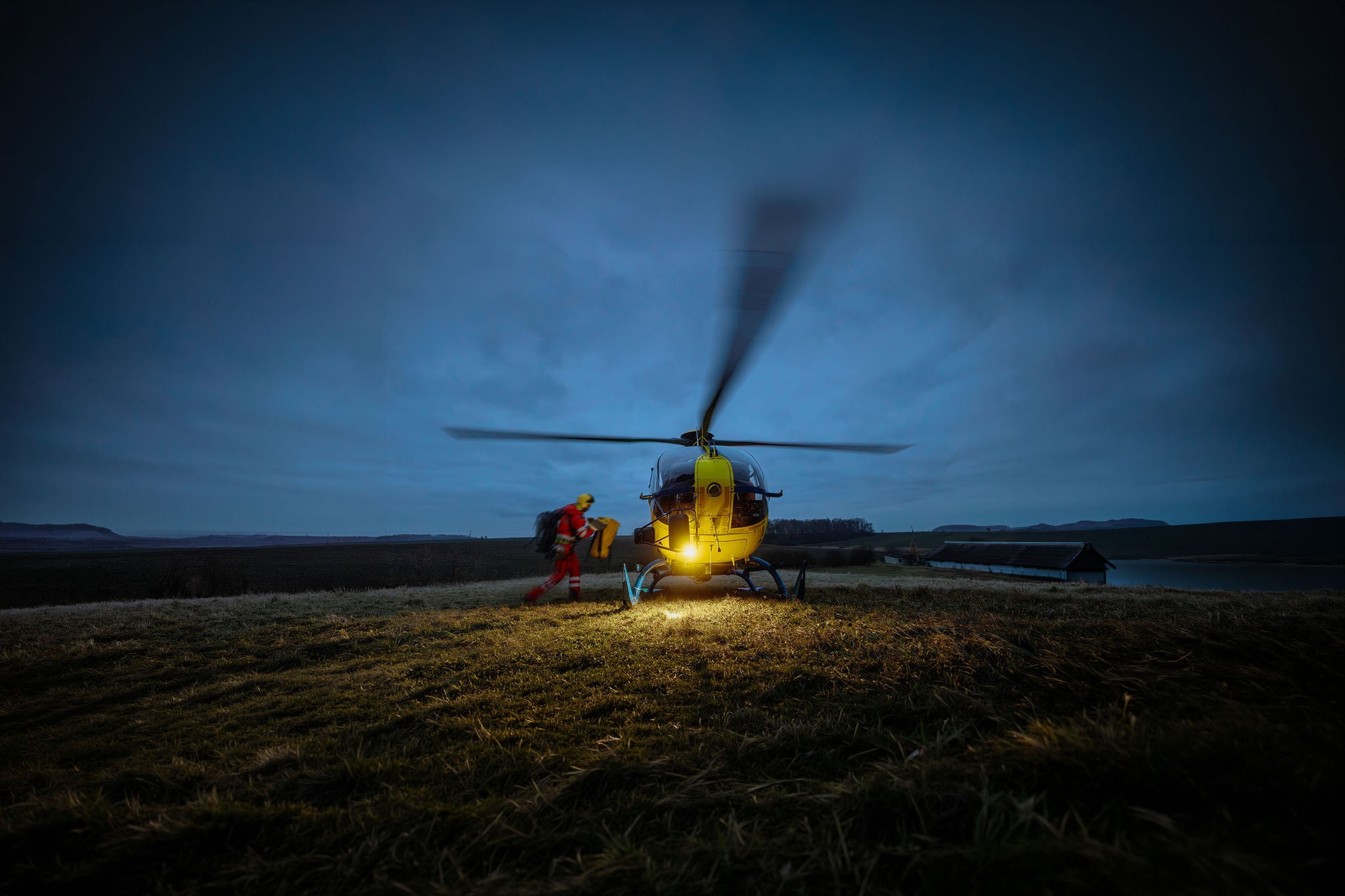 Paramedic in blurred motion running with equipment to helicopter
