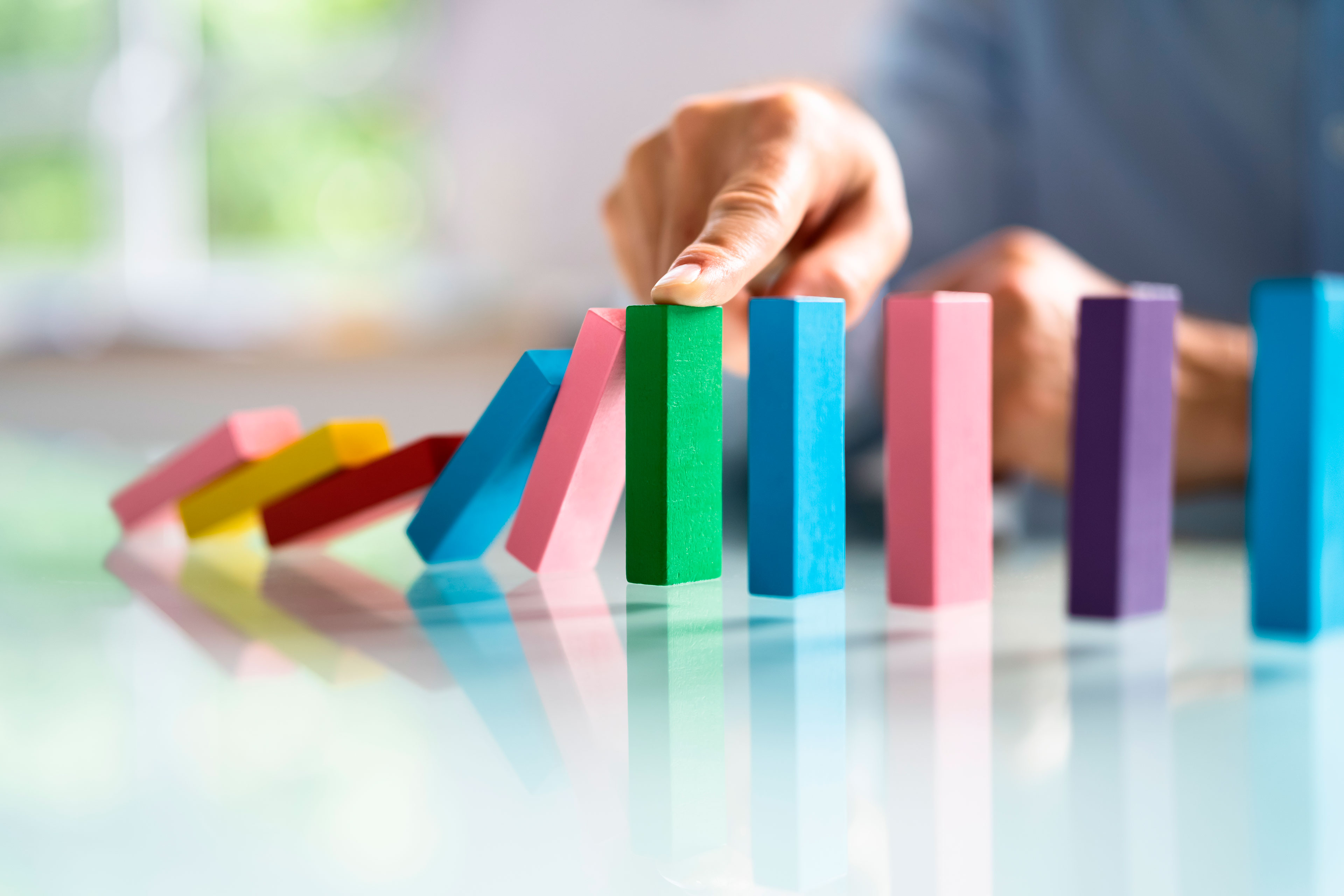 image of hand pushing colorful blocks