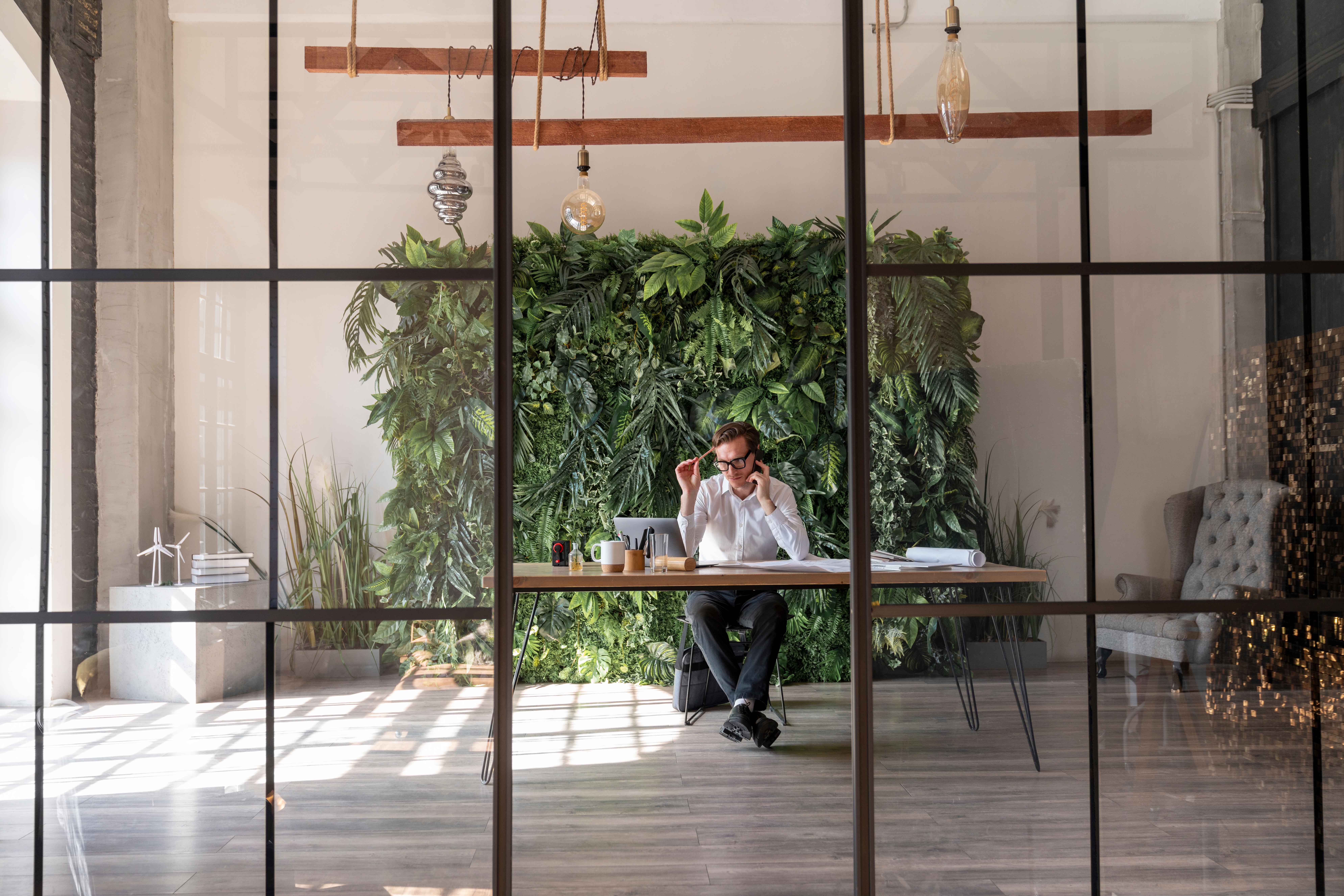 Forretningsmand sidder ved skrivebord og taler i telefon