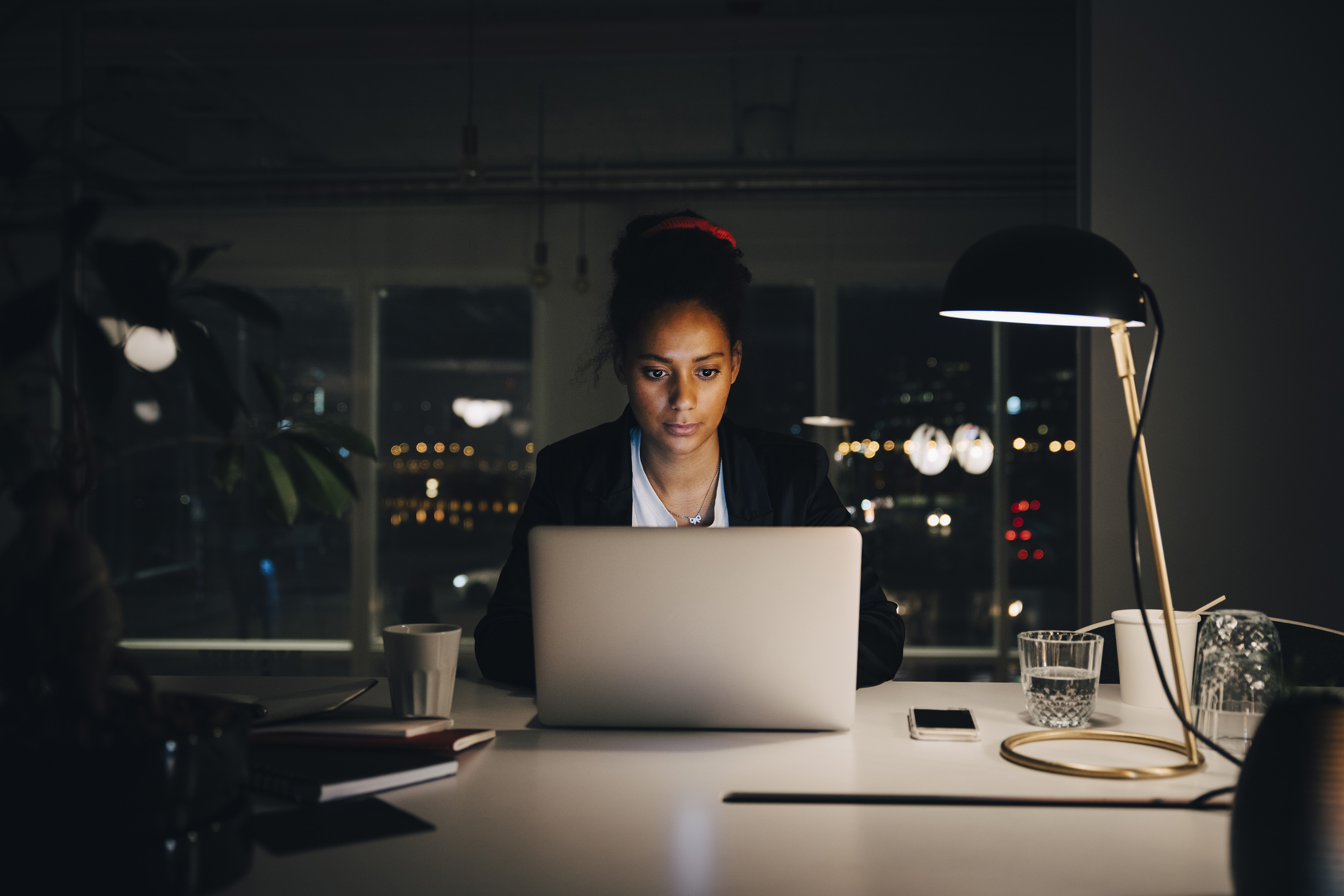 Forretningskvinde arbejder ved computer om aftenen