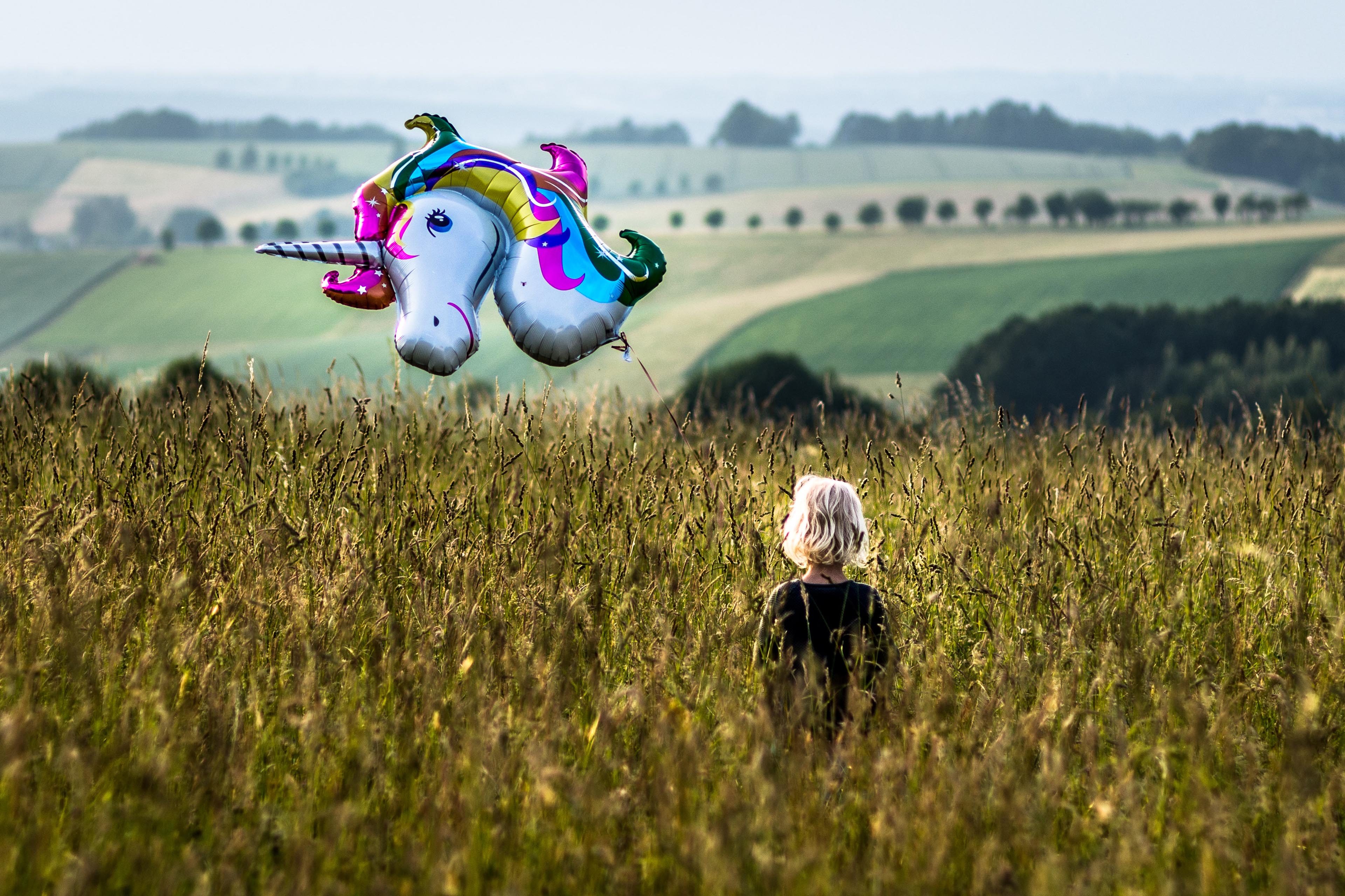 Barn står på en mark med en ballon i hånden