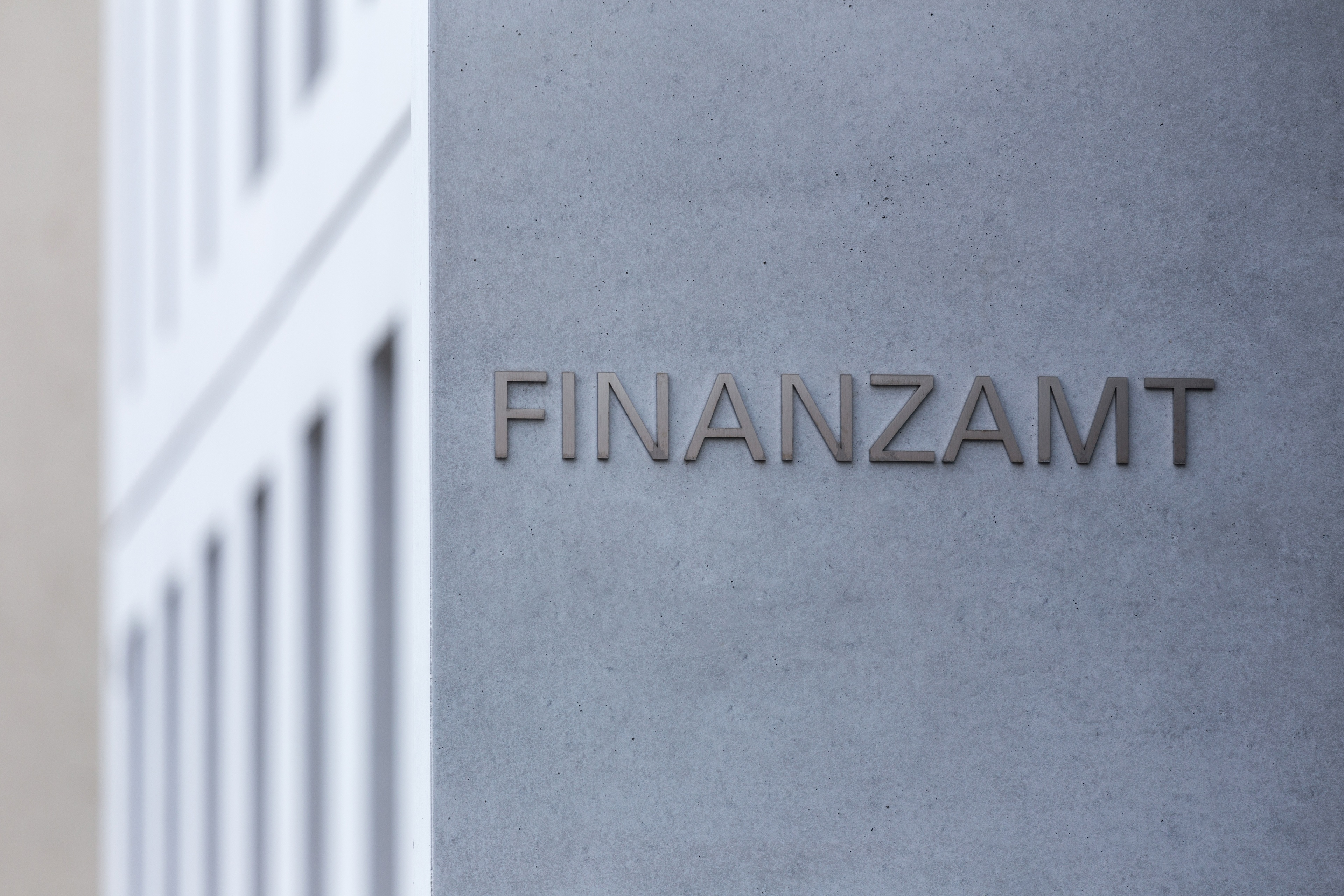 Schild des Finanzamts an der Fassade eines modernen Gebäudes