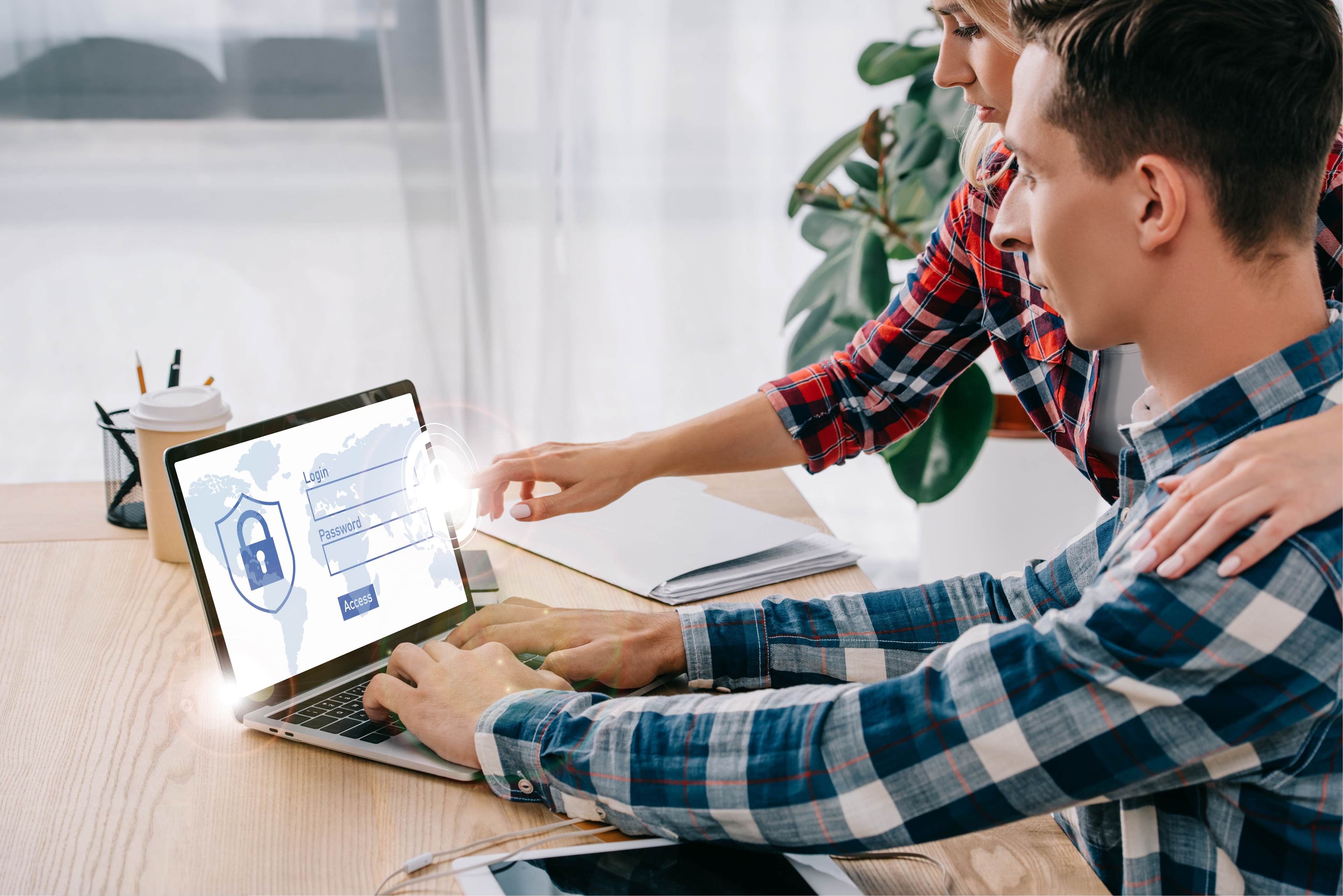 two people pointing at a laptop screen