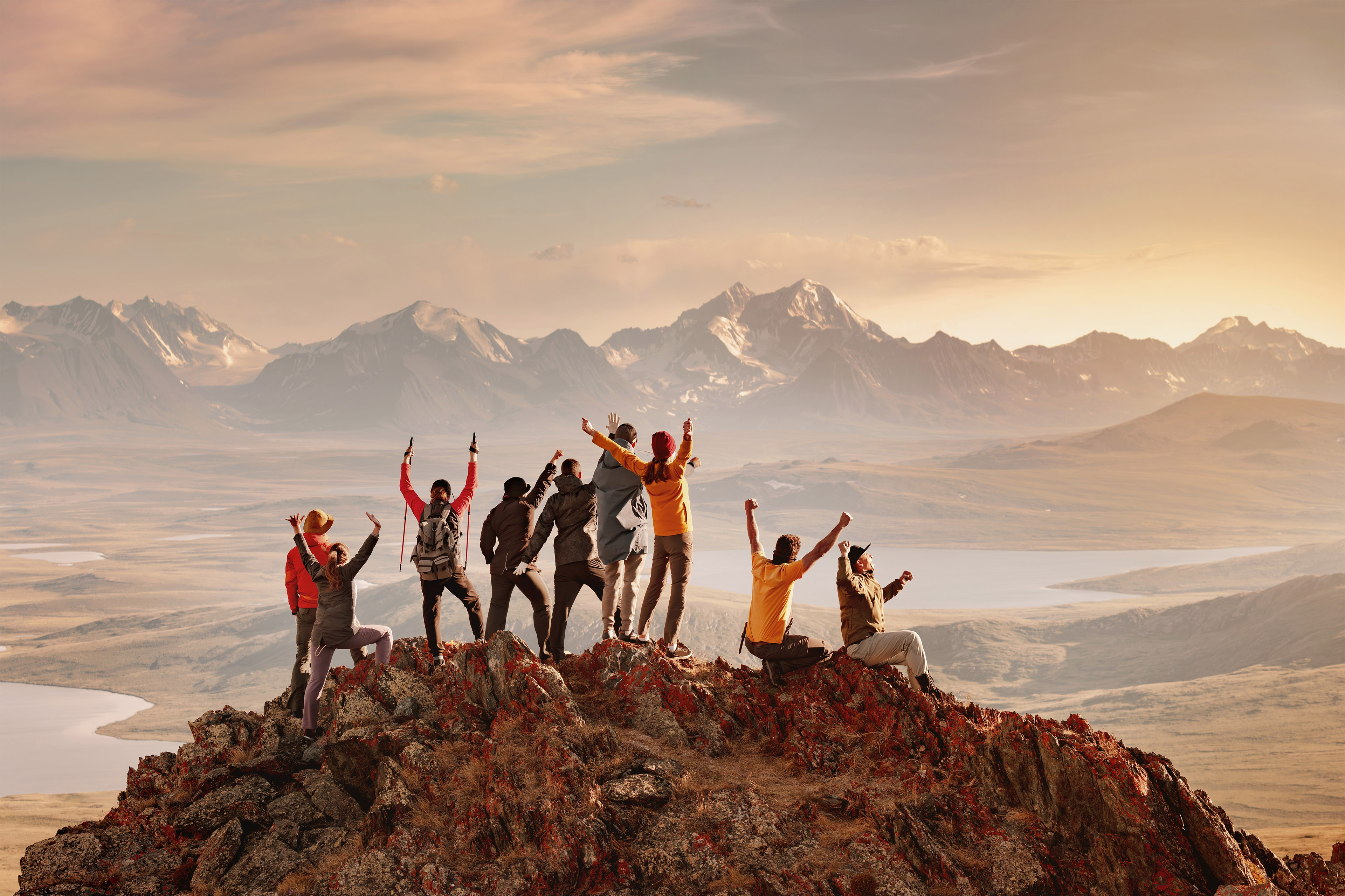 Group of hikers standing on a mountain peak overlooking a vast valley