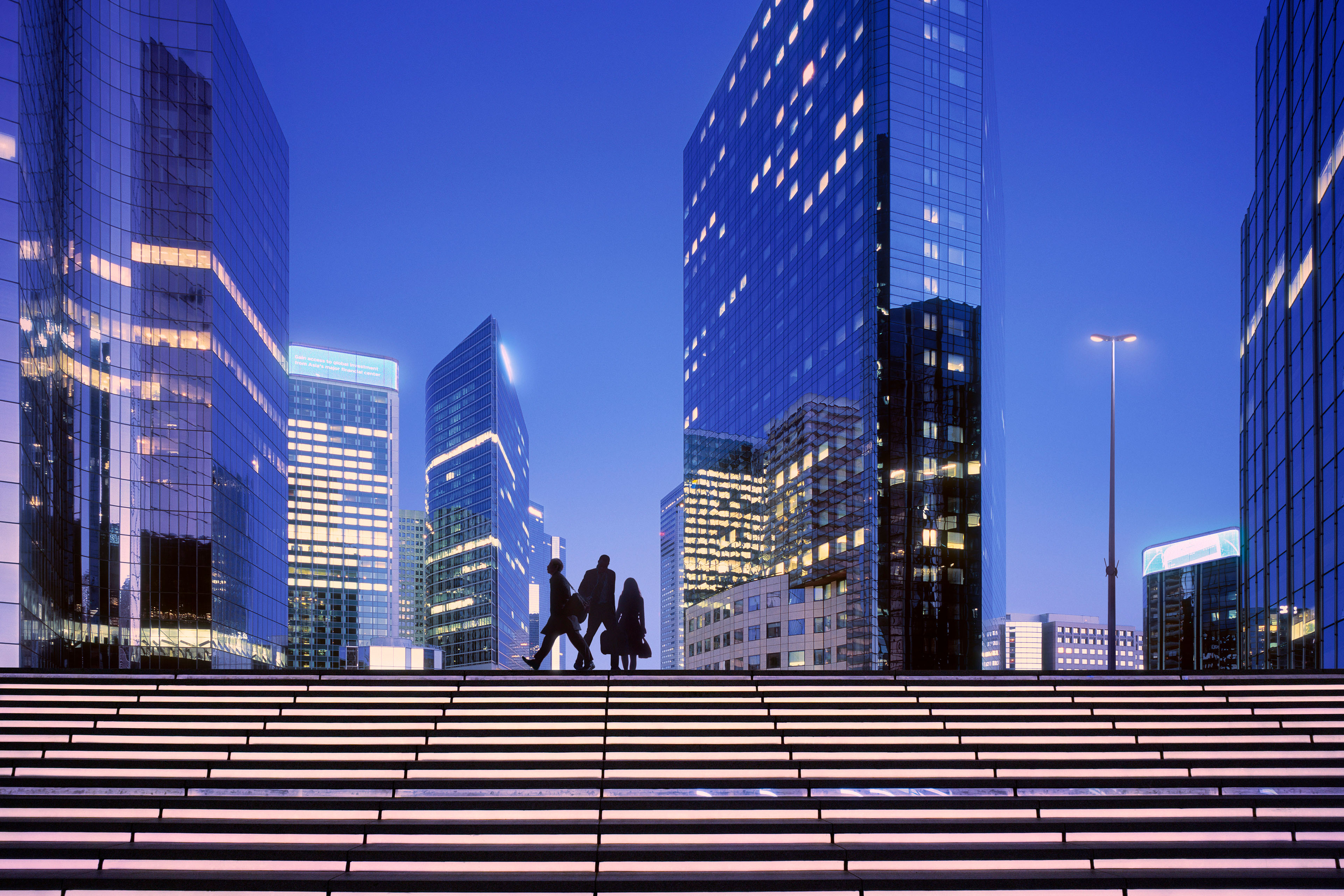A low-angle view of several modern skyscrapers with reflective glass facades