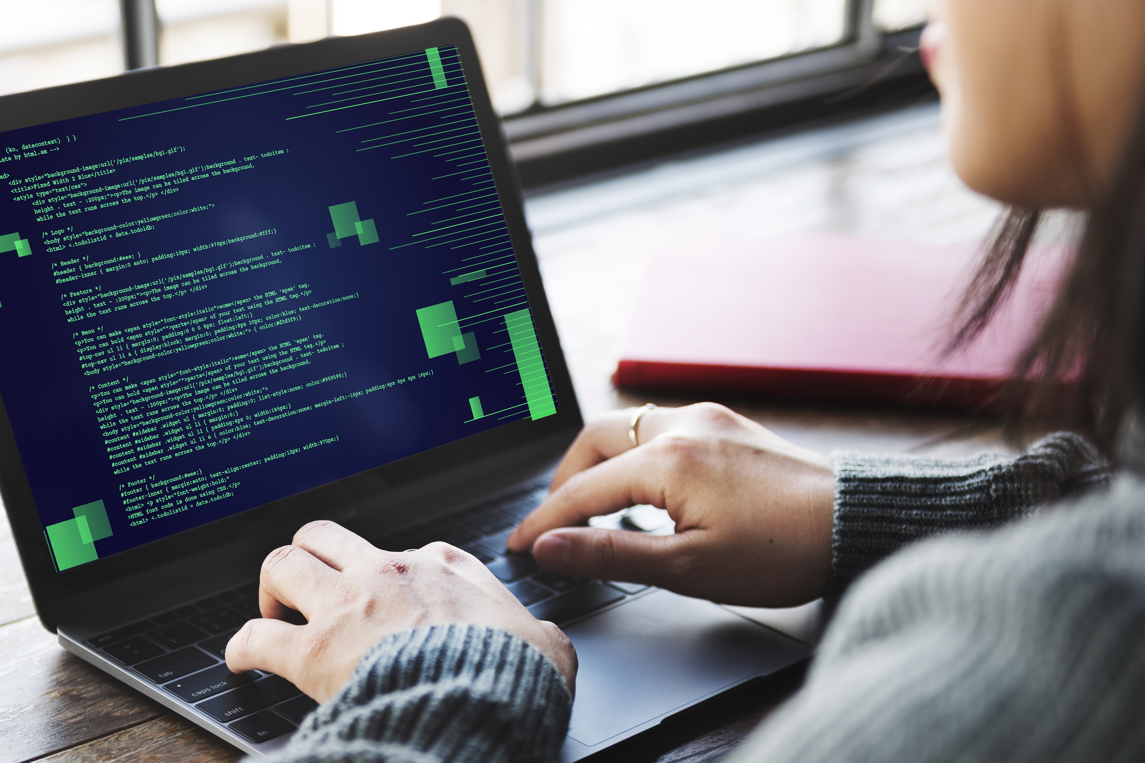 Person working on a laptop displaying computer code