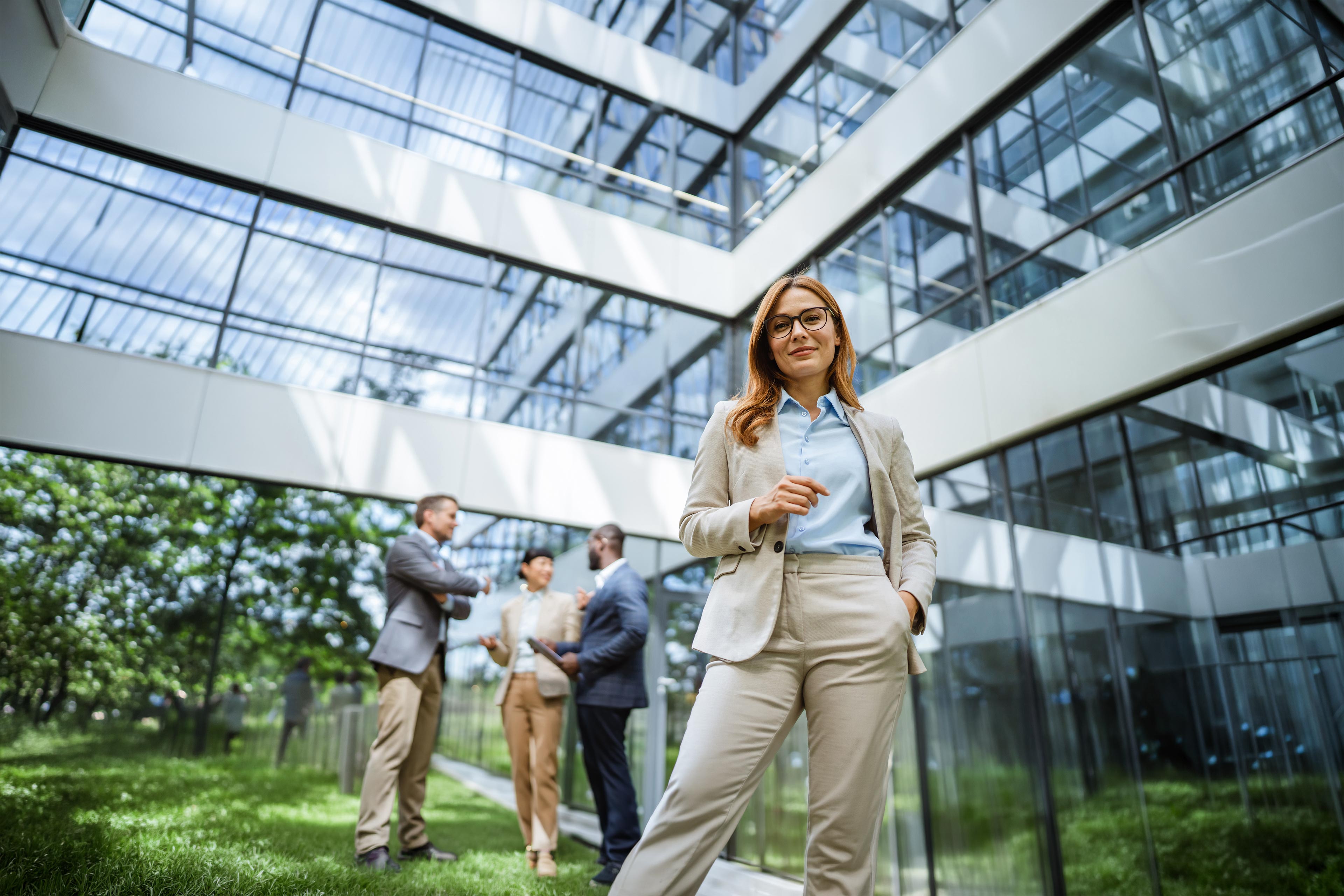 Professional outside modern office building with colleagues in background