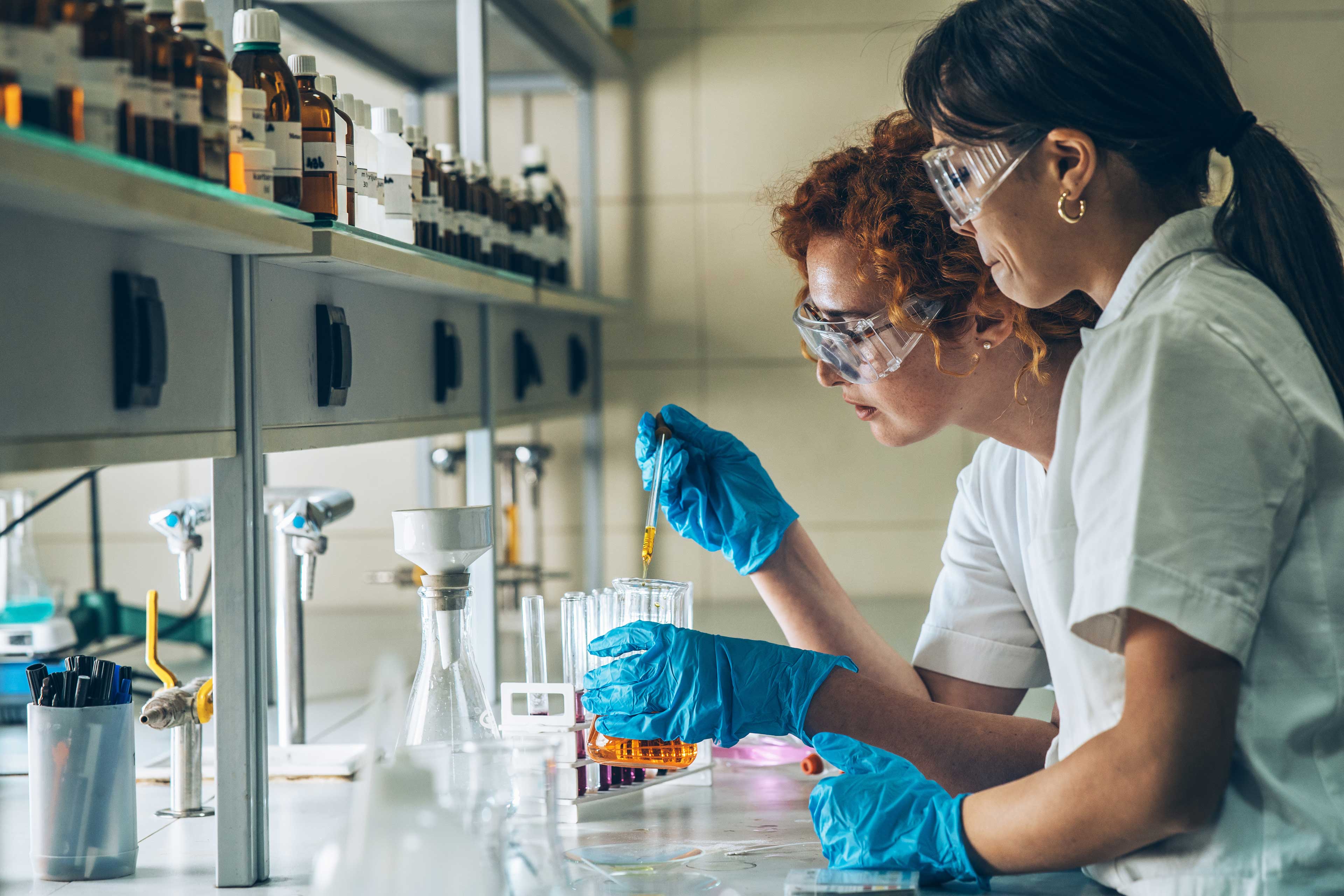 Two female chemistry scientists doing experiments in the lab.