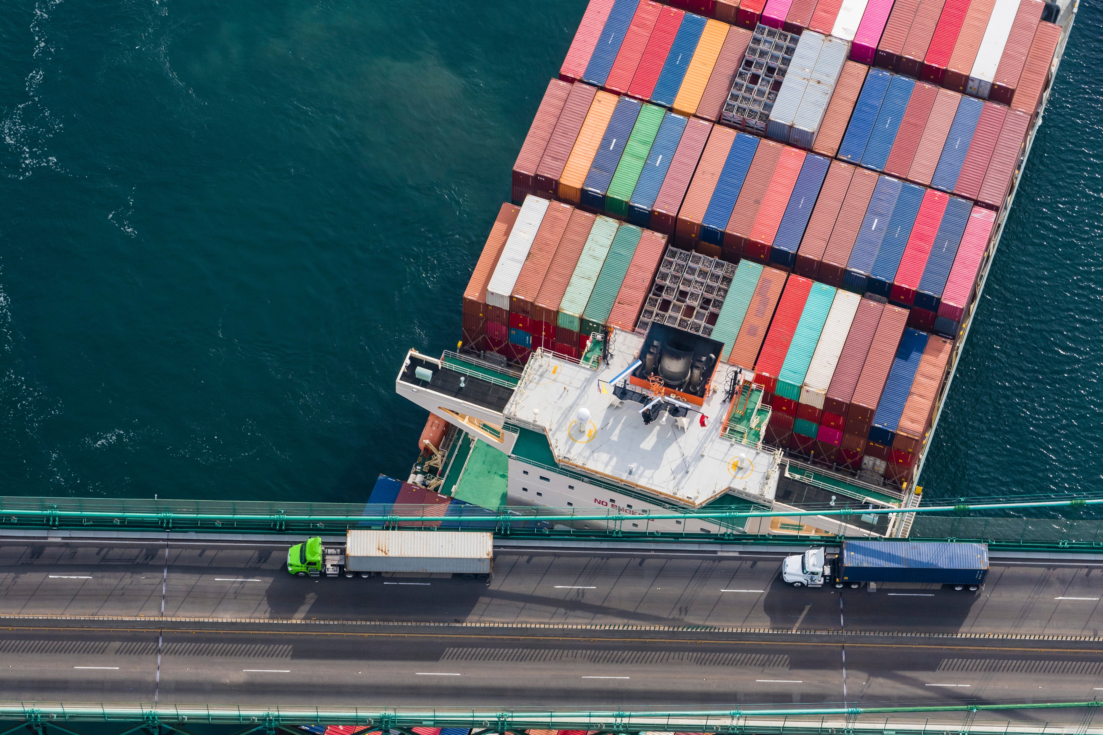  Large container ship crosses under a bridge at the port