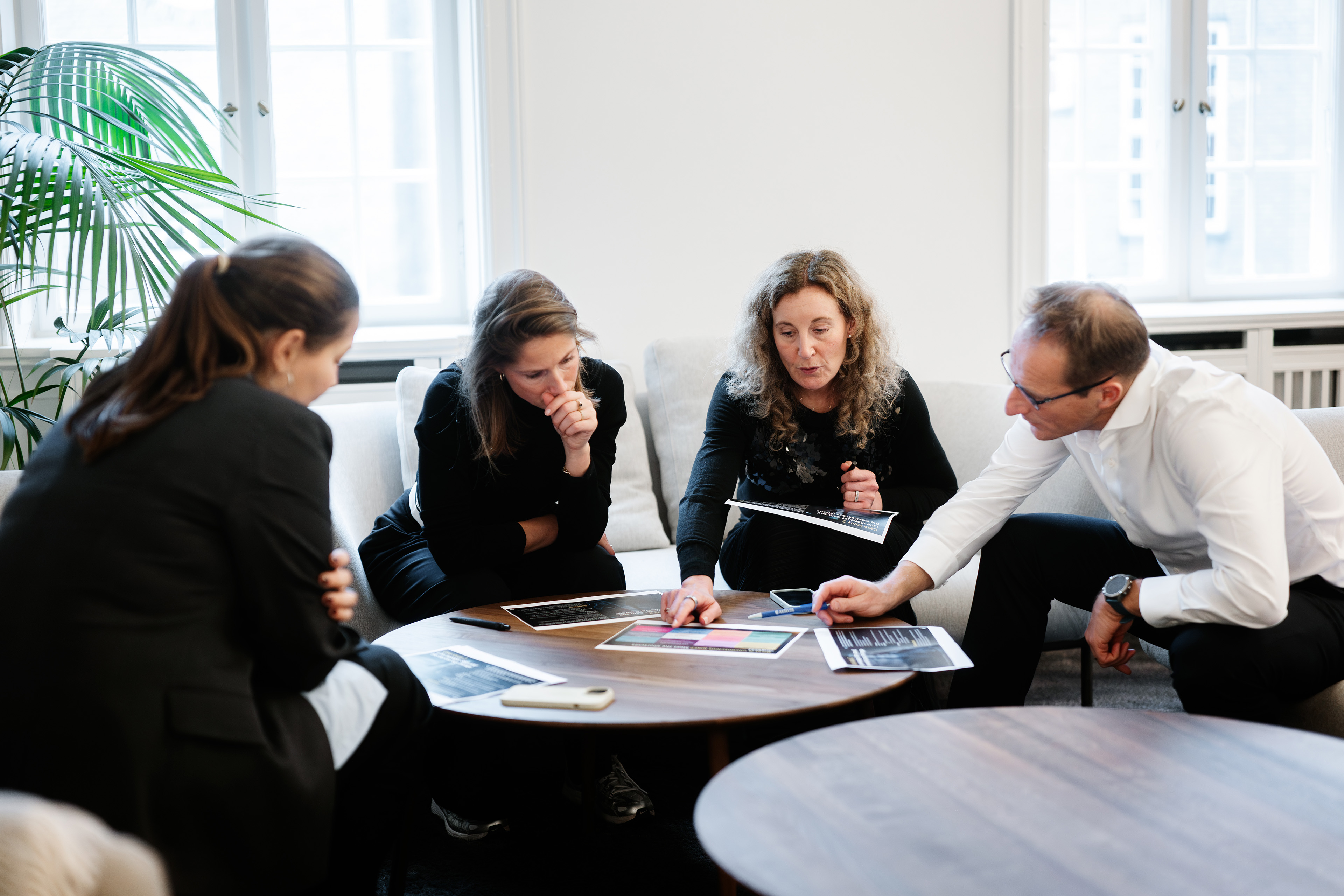 Colleagues sitting in cozy area looking at presentation