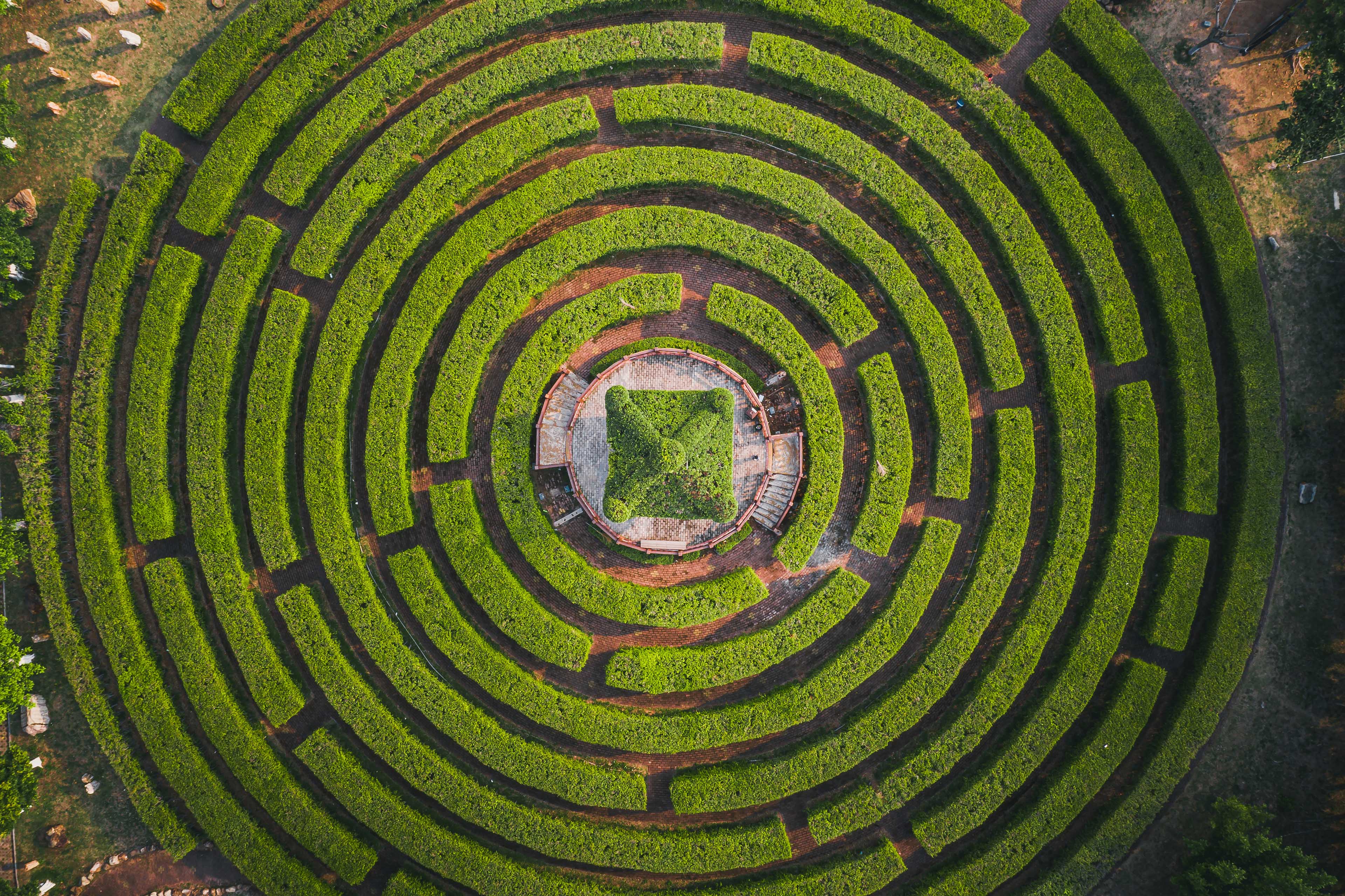 Aerial view of a circular garden maze and green pavilion