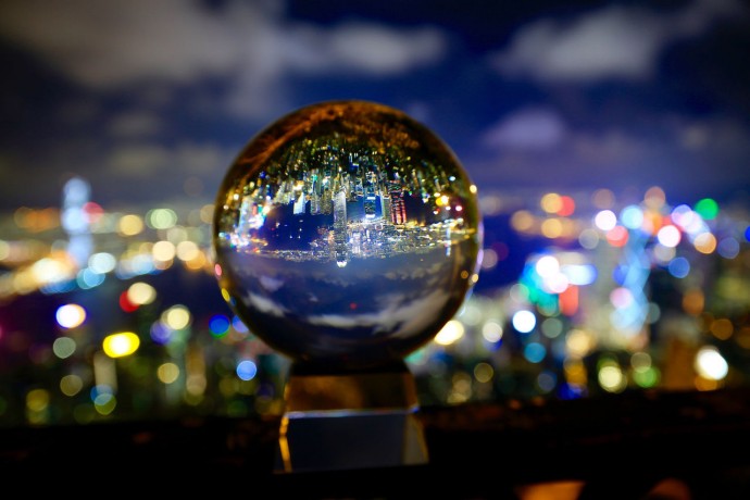 Close up of illuminated city seen in crystal ball at night