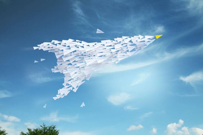 Paper planes in the shape of an airplane in the sky