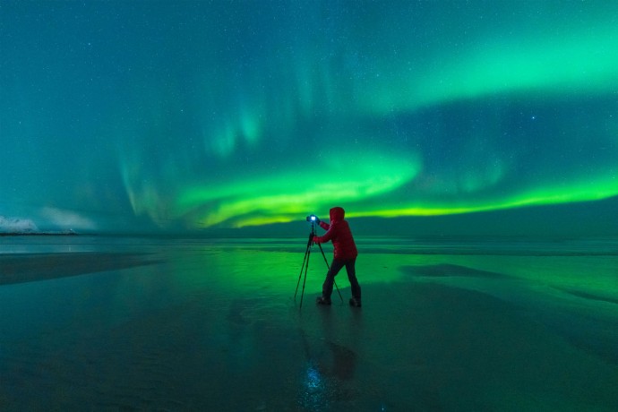 Photographer on skagsanden beach during northern lights
