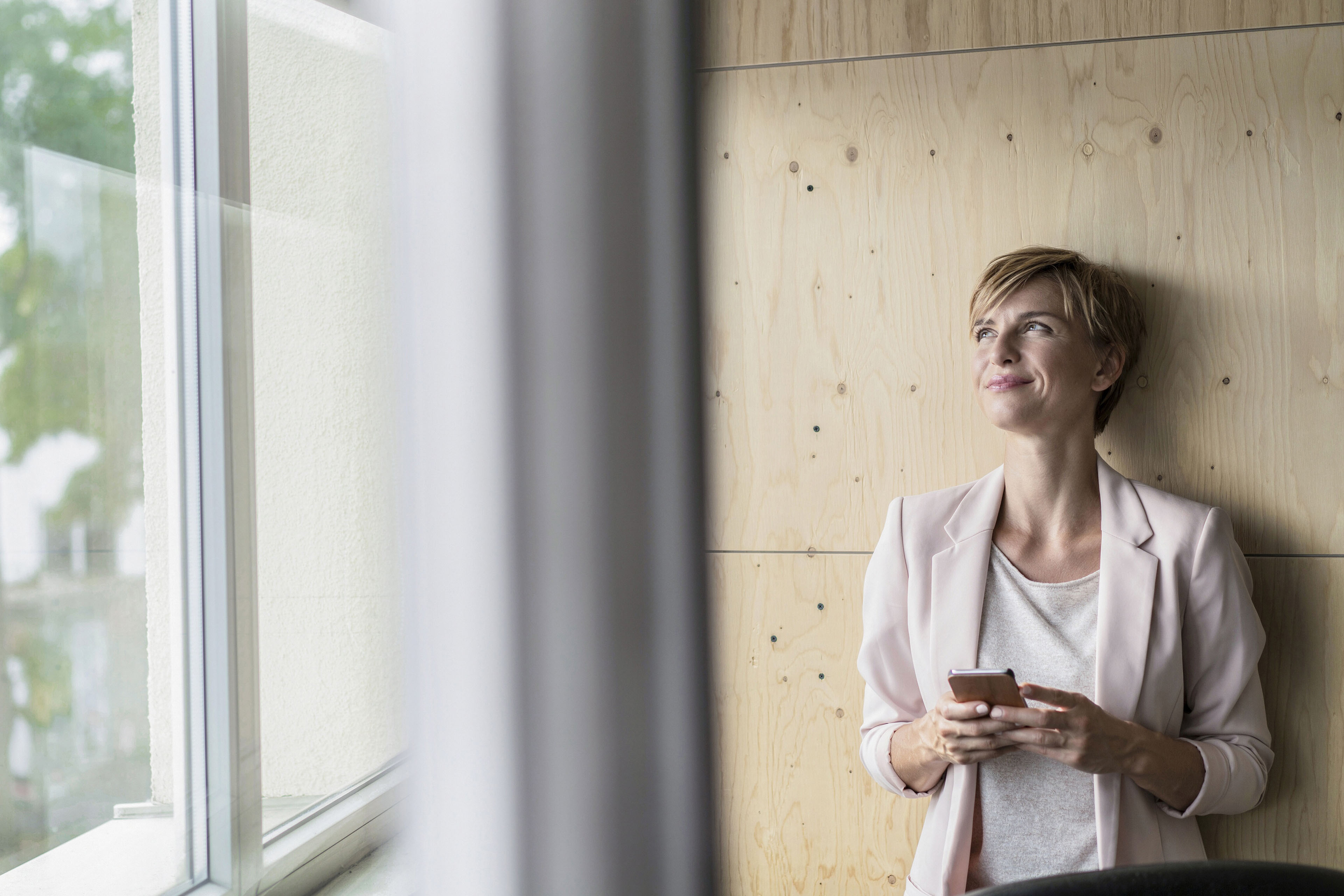 Smiling businesswoman using cell phone in office