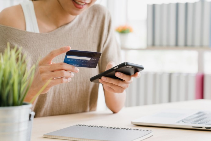 woman using smartphone and credit card for online shopping