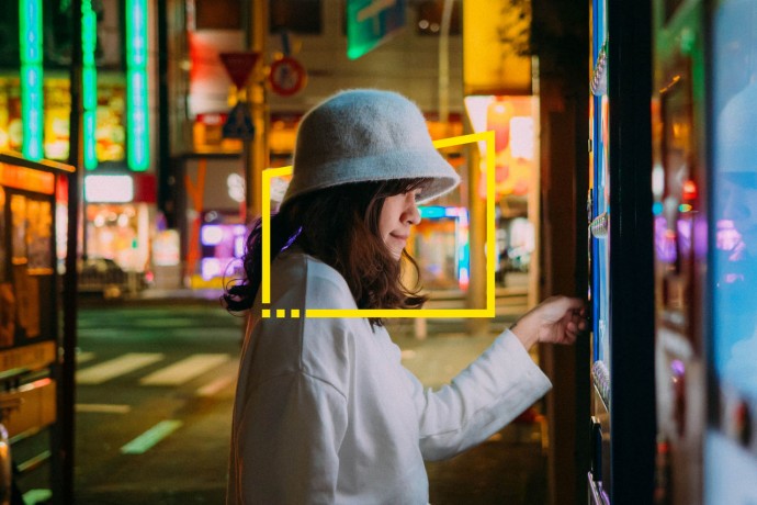 Asian woman selecting some drink at vending machine