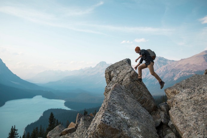 A man standing on a rocky point overlooking peyto lake