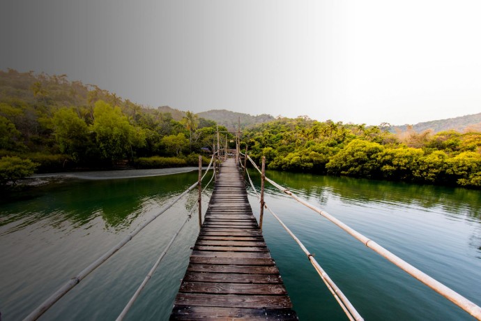 Walkway bridge made of wooden planks and leading to an island