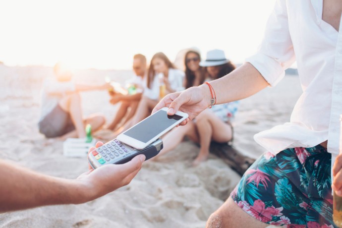 Man paying smart phone on beach