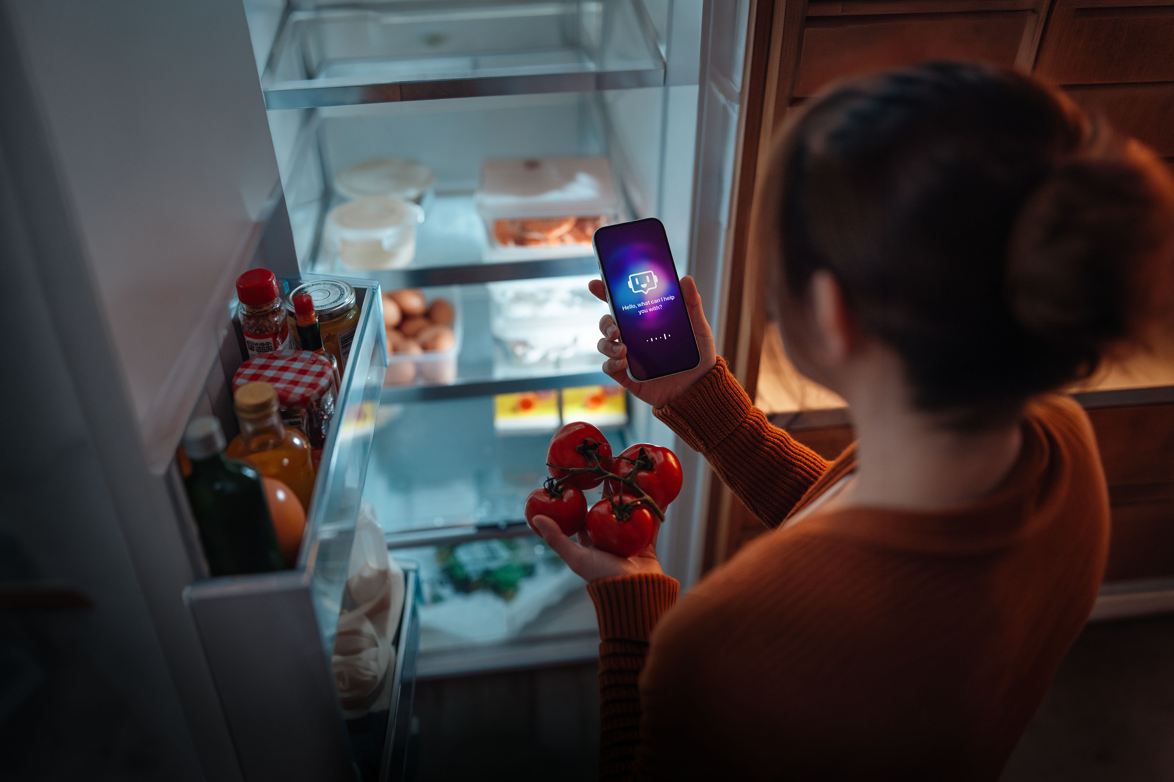 Woman using AI technology on smartphone to track fridge inventory