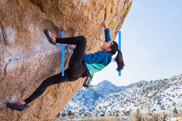 Girl climbing rock in mountains.