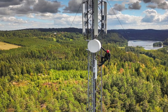 Telecommunications Engineer on Communication Tower in the Middle of Forest
