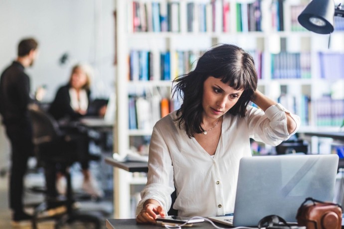 Businesswomen looking at laptop while sitting in office
