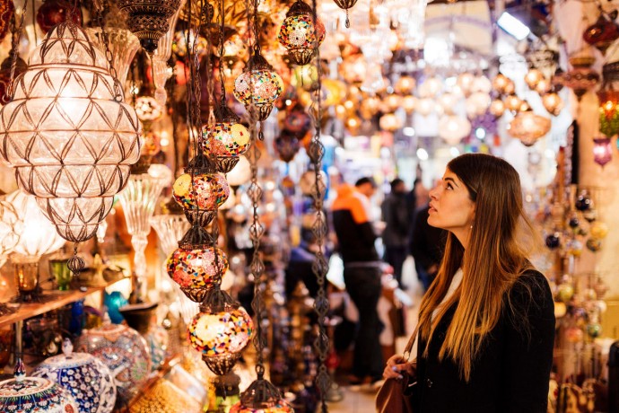 Woman looking at lamps in bazaar