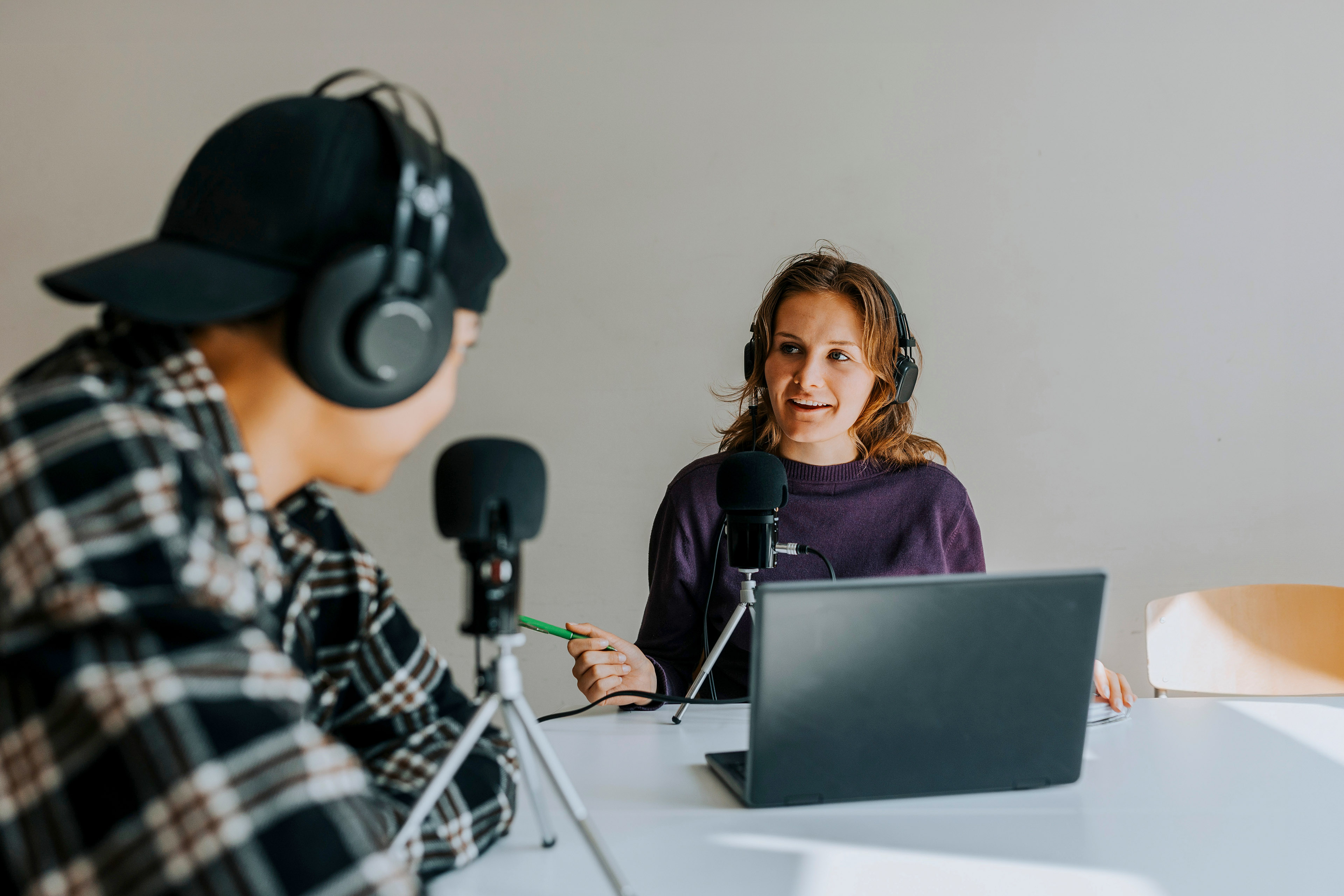 Young man and woman talking during podcast recording