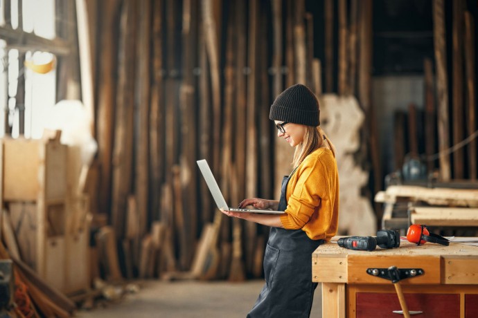 Female carpenter working on laptop