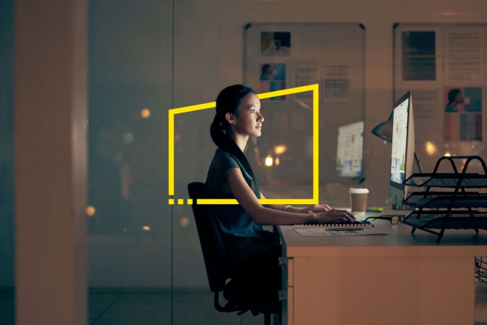 Businesswoman using a computer at night in a modern office
