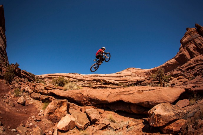  A man getting air on a jump on his mountain bike near moab, utah market data background