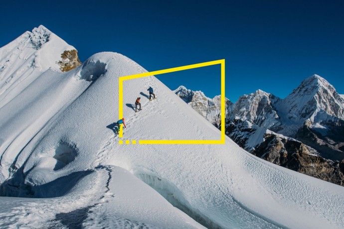 Three people climbing a mountain