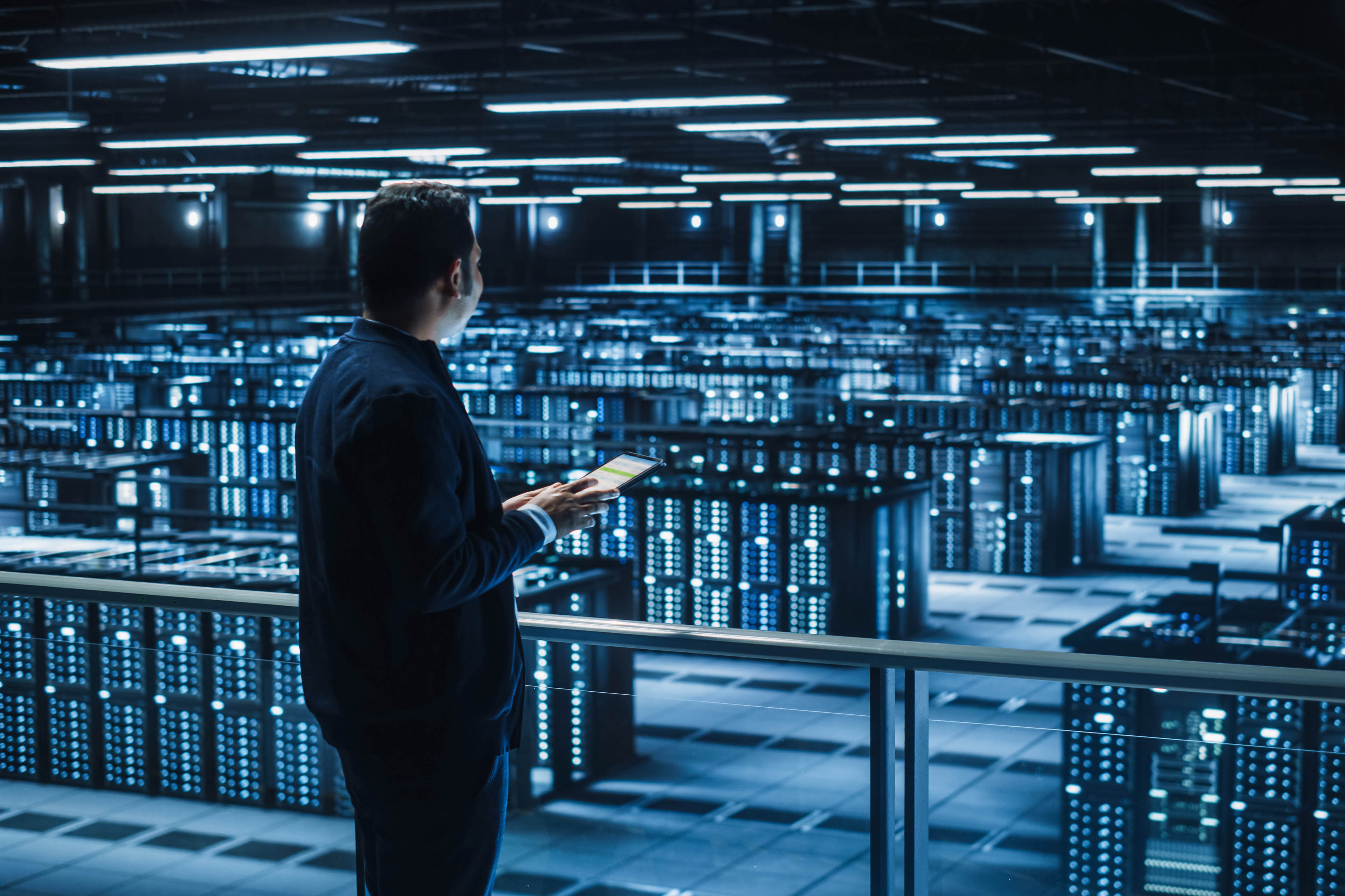 Succesful Businessman and e-Business Entrepreneur Overlooking Server Farm Cloud Computing Facility.