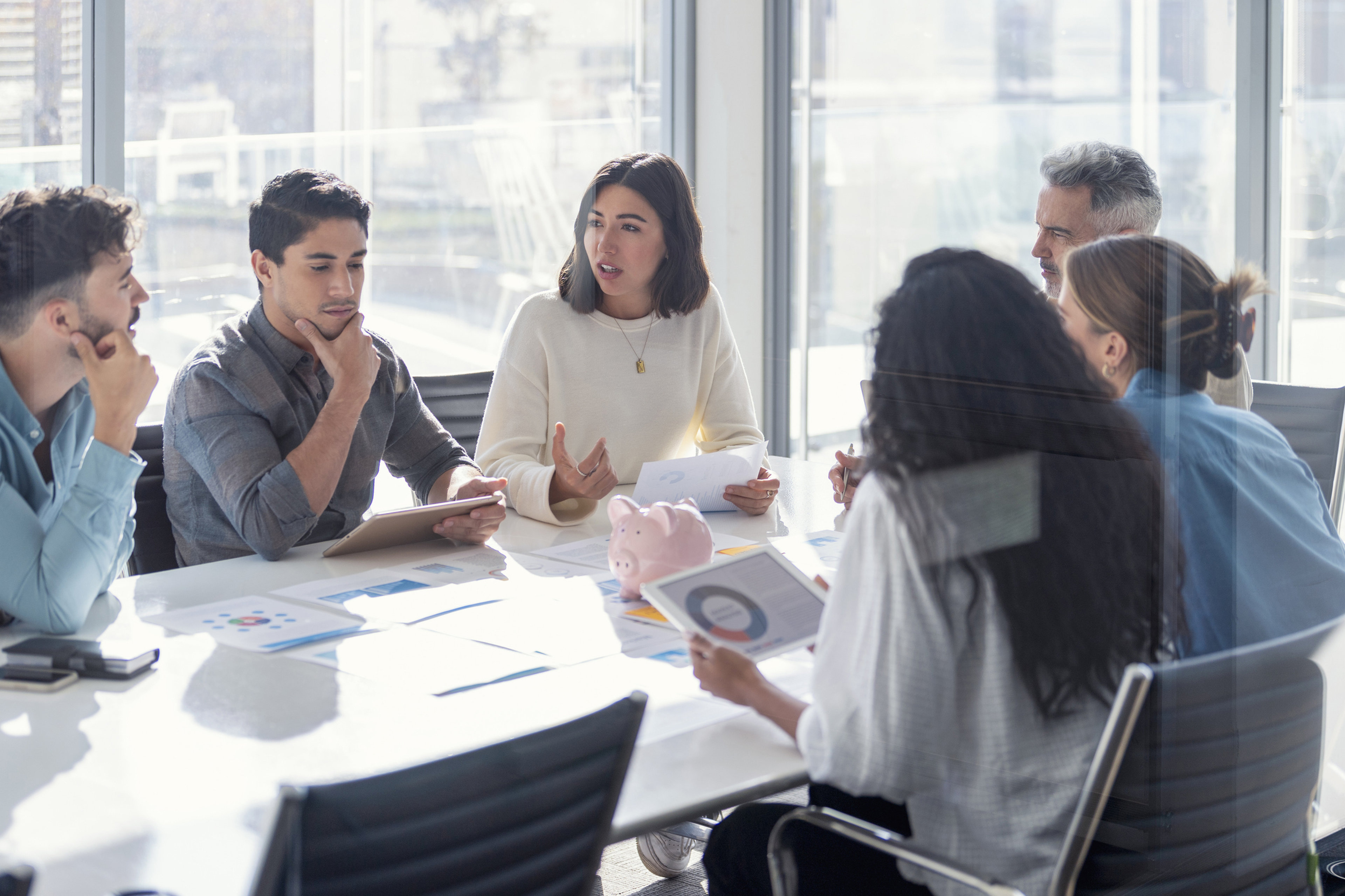 Multi racial group of Business people with a piggy bank. 