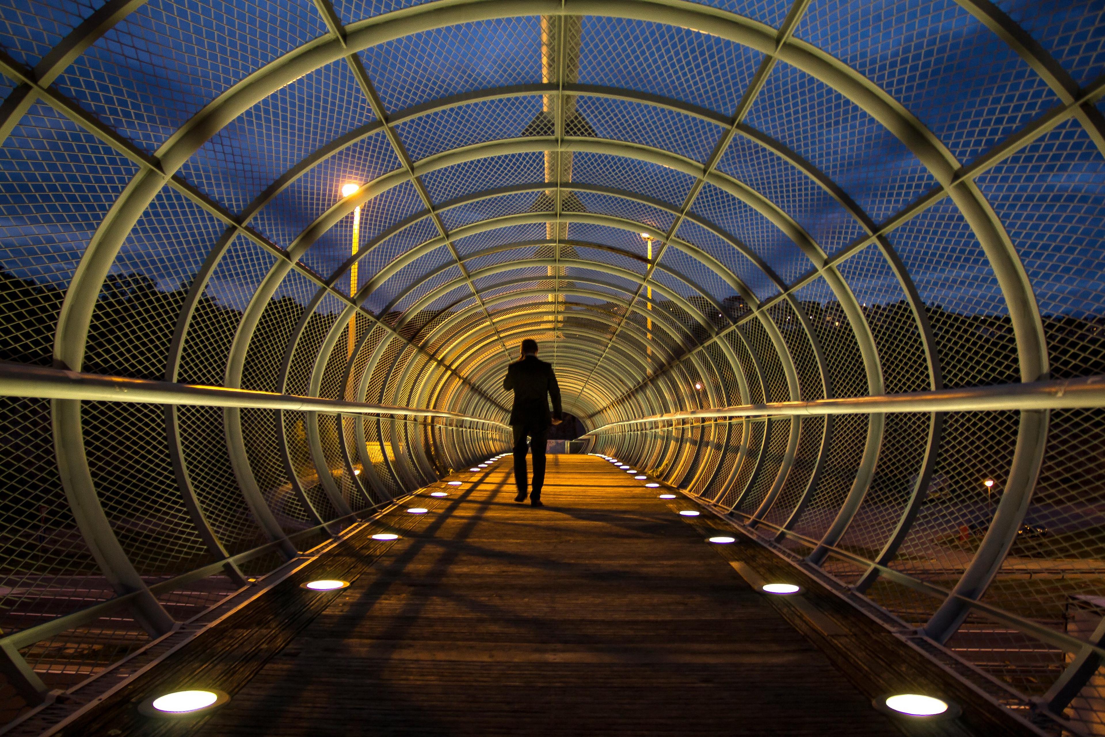 Person standing on bridge viaduct with circular steel construction