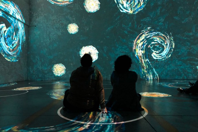 People sitting in physical distancing circles at immersive van gogh exhibit