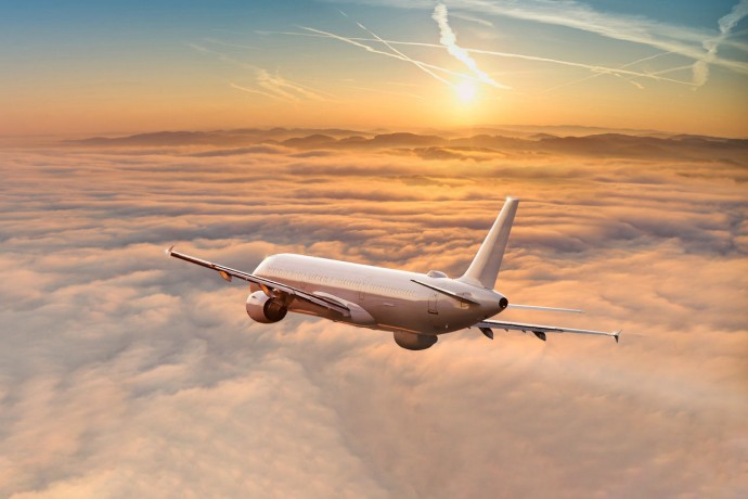 Panorama view of an airplane flying above dramatic clouds