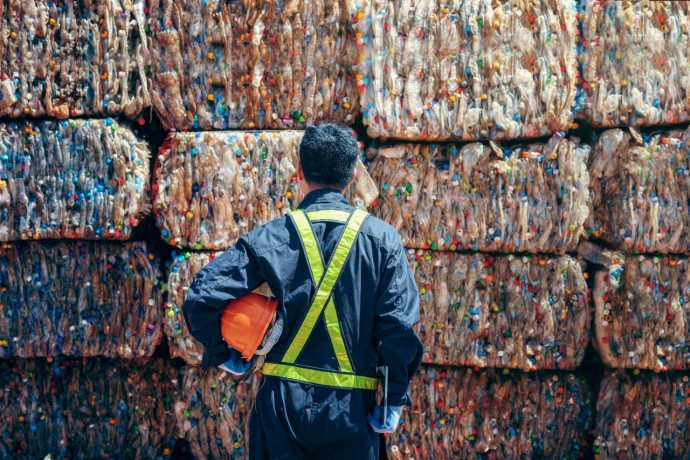 Man standing and looking back the plastic bottle in the recycling industry