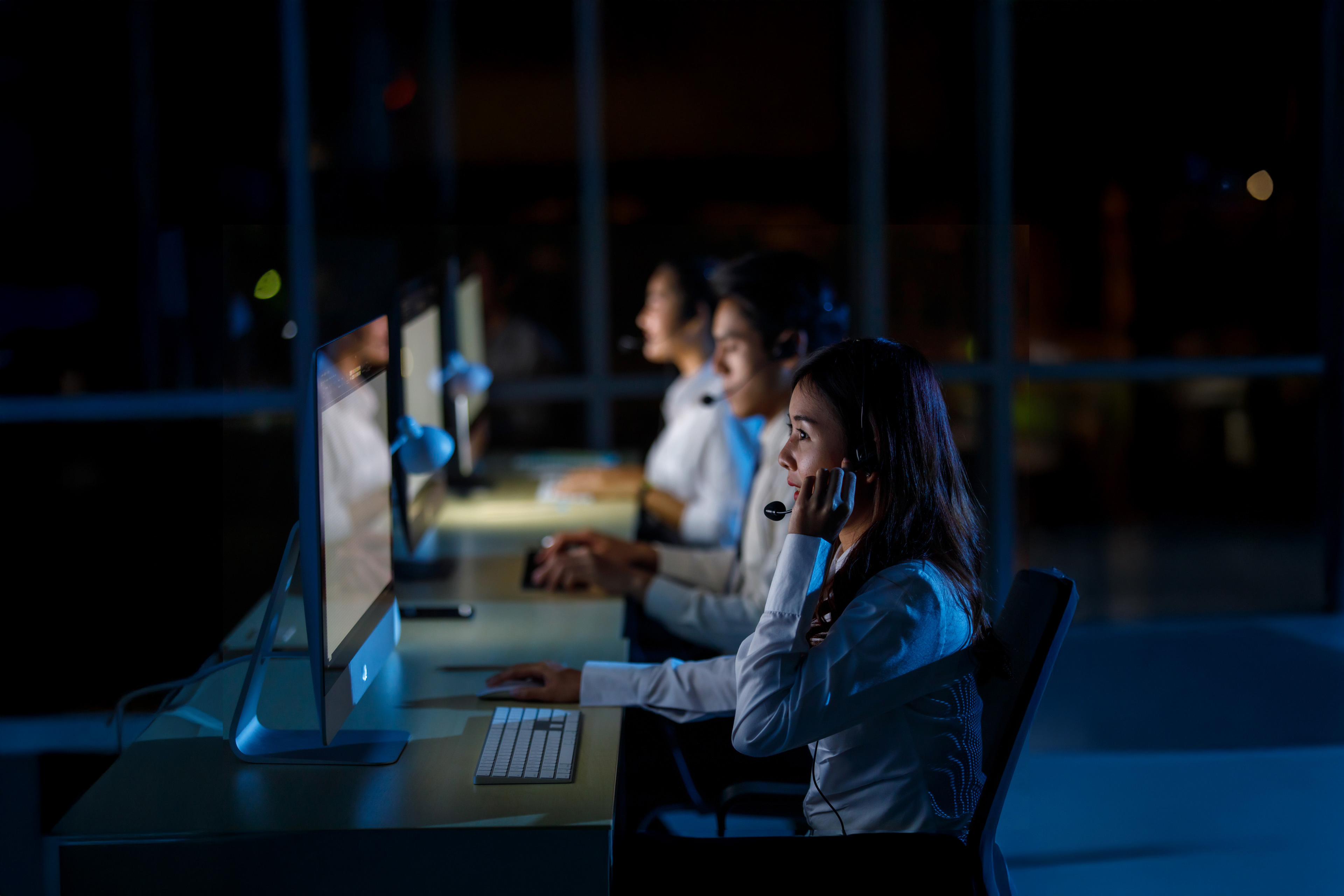 Asian professional female assistant service helpline operator wearing headphone microphone