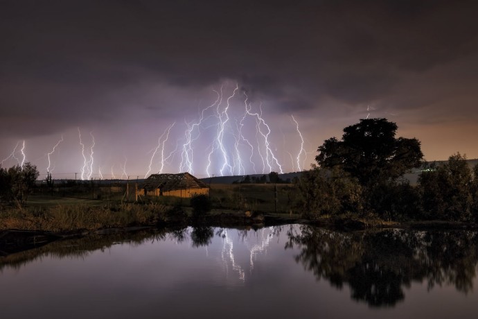 Lightning strikes over abandoned farmhouse
