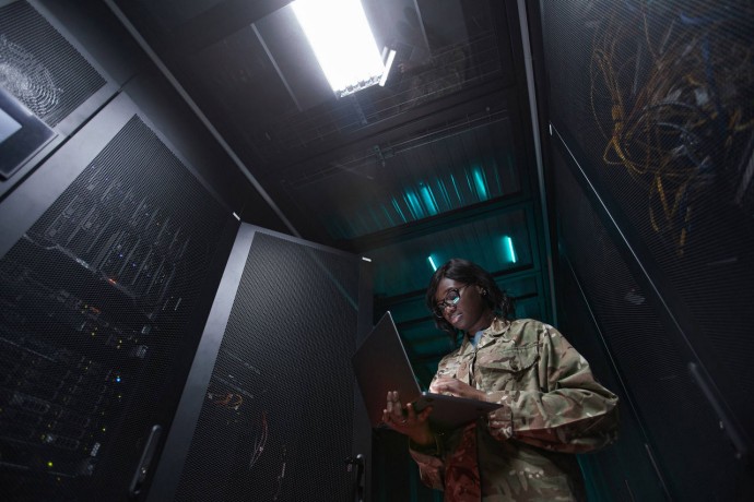 Military network technician inspecting server